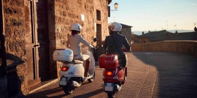 Young man and woman on a Vespa Scooter. Bikers couple in Italy.