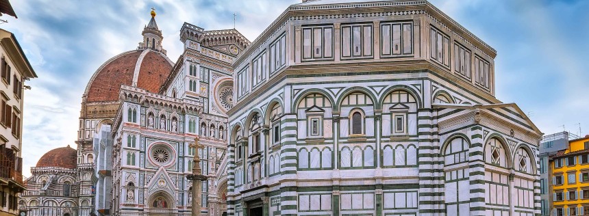 People on the square near historical medieval Duomo Santa Maria Del Fiore and Baptistery in old town, cloudy blue sky